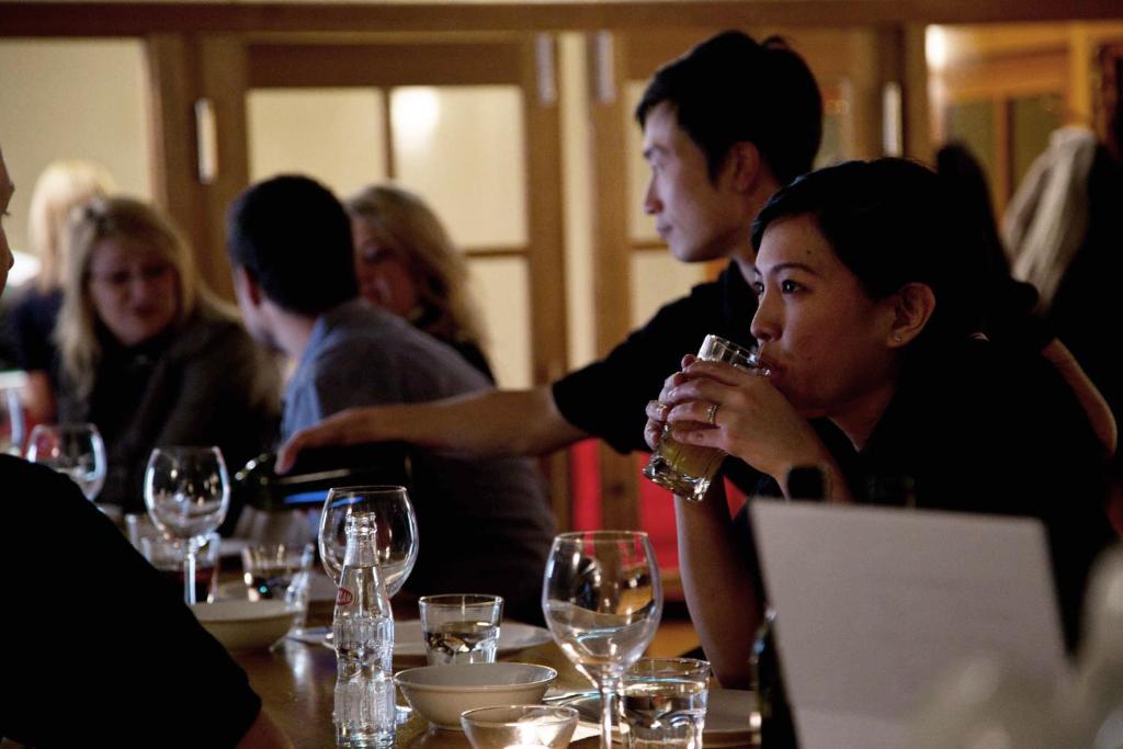 a group of people sitting at a table with wine glasses at Double Black Hotel in Hakuba