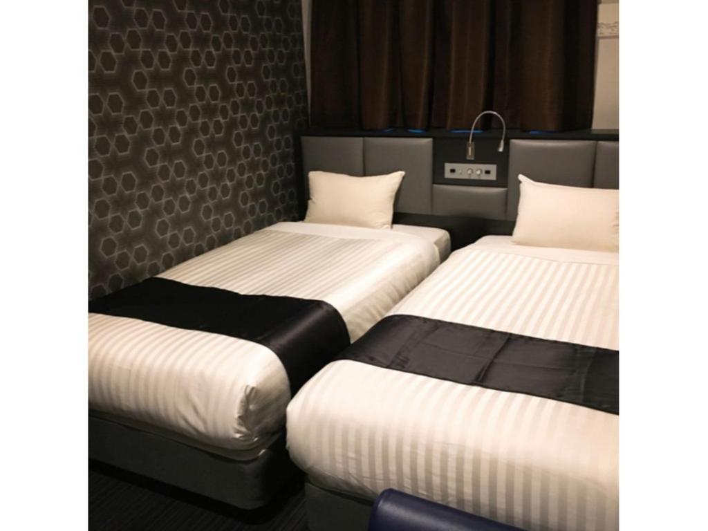 3 camas en una habitación de hotel con en Hotel Hulaton Fukuokahakata - Vacation STAY 04210v en Fukuoka