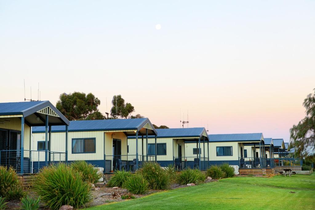 a row of modular homes with blue roofs at Discovery Parks - Whyalla Foreshore in Whyalla