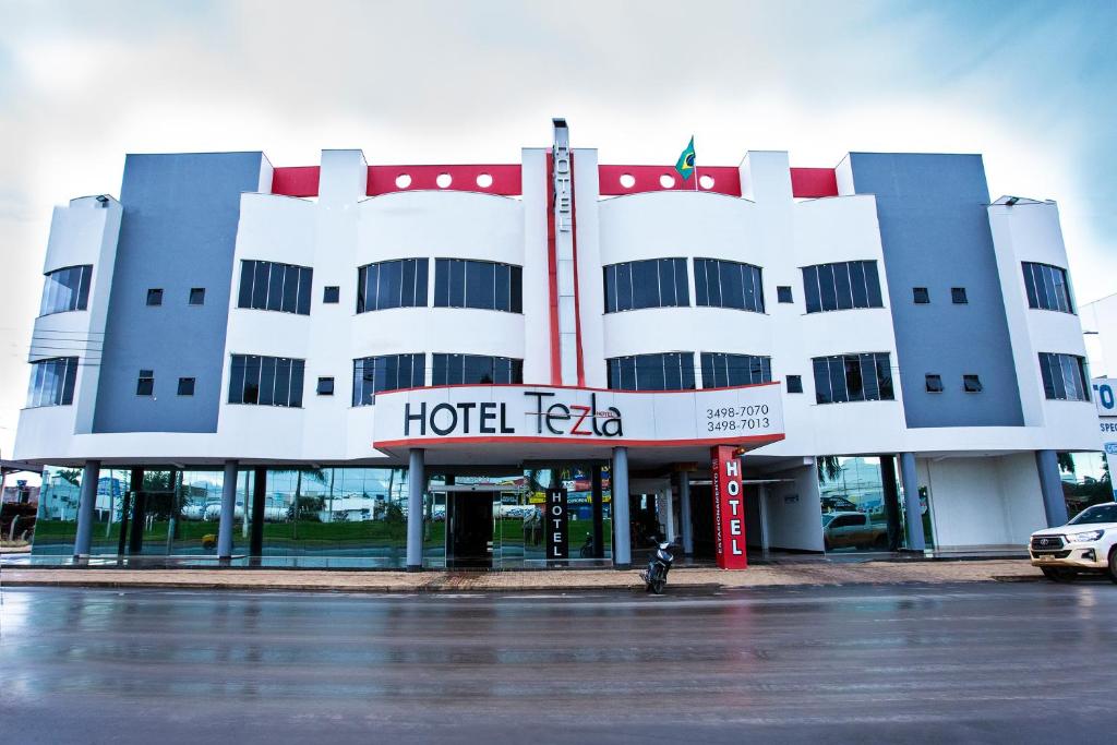 a hotel faza with a parking lot in front of it at Tezla Hotel in Primavera do Leste