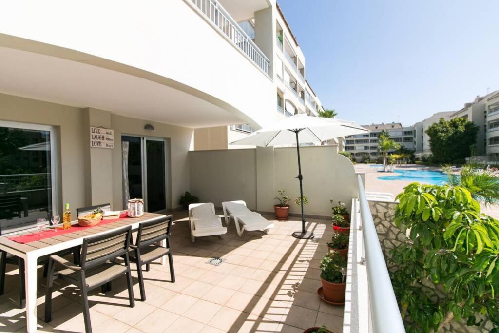 a patio with a table and chairs and an umbrella at Apartamento San Remo Soleado in Palm-Mar