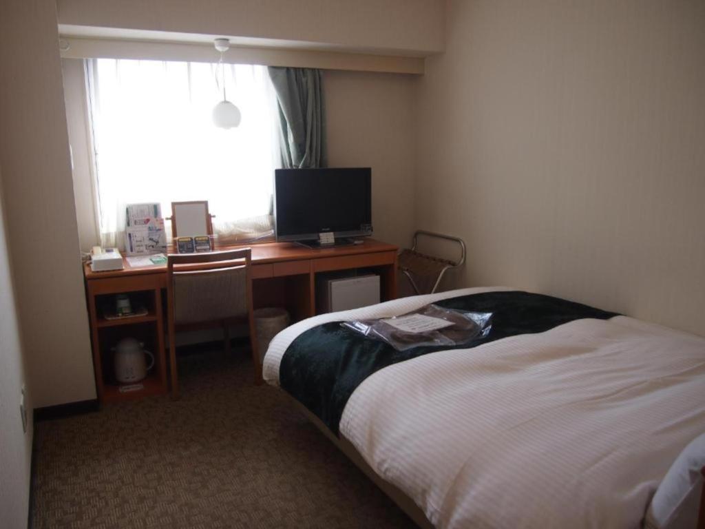 a bedroom with a bed and a desk with a computer at Hotel Taisei Annex - Vacation STAY 05181v in Kagoshima