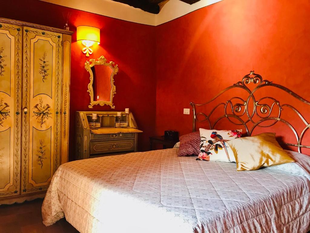 sypialnia z czerwonymi ścianami, łóżkiem i lustrem w obiekcie La terrazza w mieście Cori