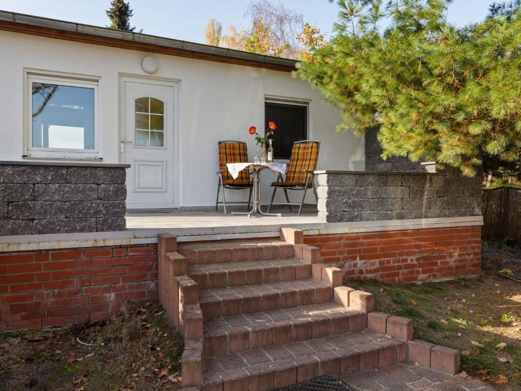 una casa con patio con mesa y sillas en Cozy Bungalow in Werder with Garden en Petzow