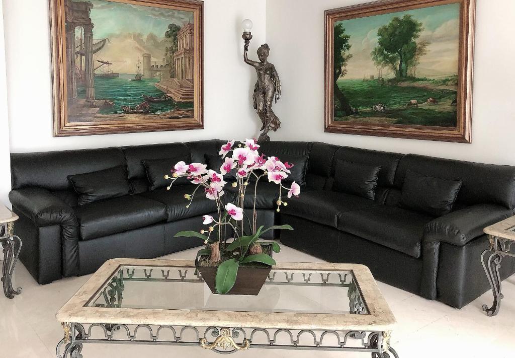 a living room with a couch and a table with flowers at Hotel Boulevard in Lima