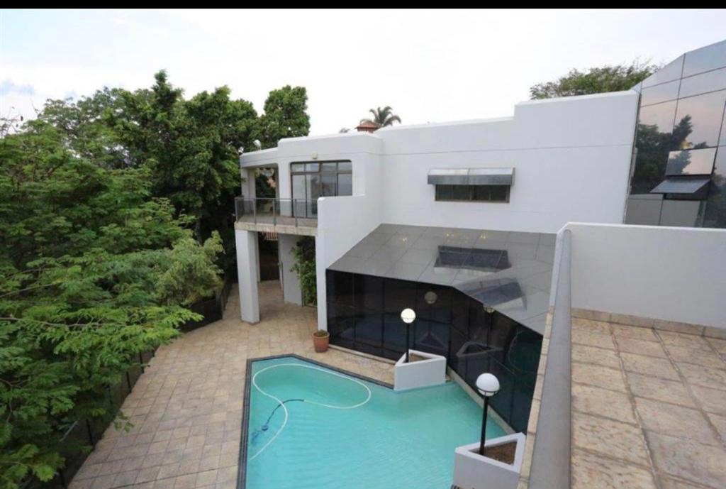dom z basenem przed nim w obiekcie The Palace Guesthouse & Garden Restaurant w mieście Pretoria