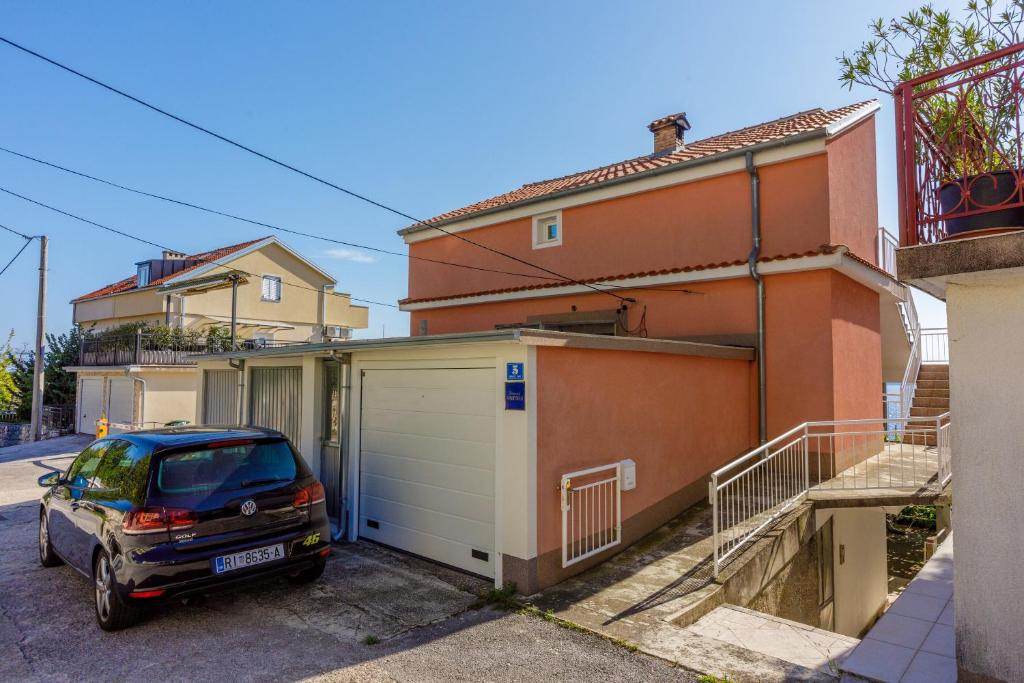 a car parked next to a house with a garage at Apartment Davor in Dramalj