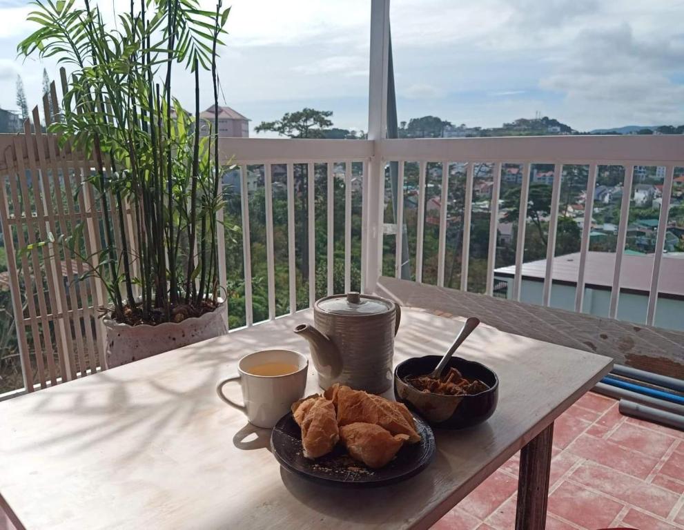 un tavolo con un piatto di cibo e una tazza di caffè di Forelsket 2 a Da Lat