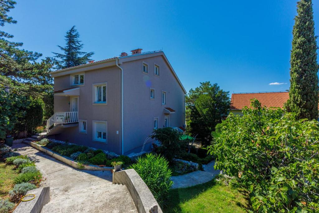 a large house with trees and bushes at Apartments Robic in Selce