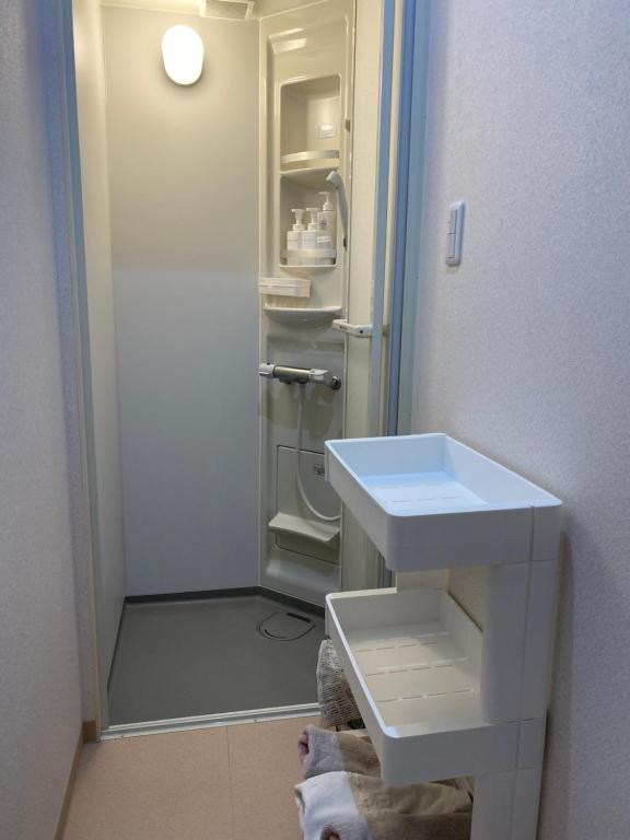baño con lavabo y nevera abierta en ロハス伊江島, en Ie