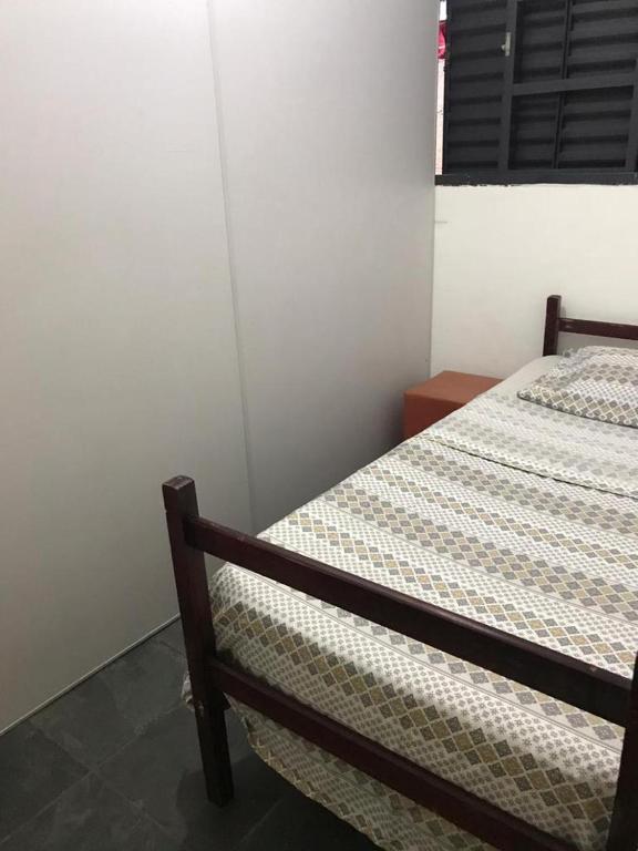 uma cama num quarto com um espectro de roupa de cama, um senal senalsenal em Pousada Fran em São Paulo