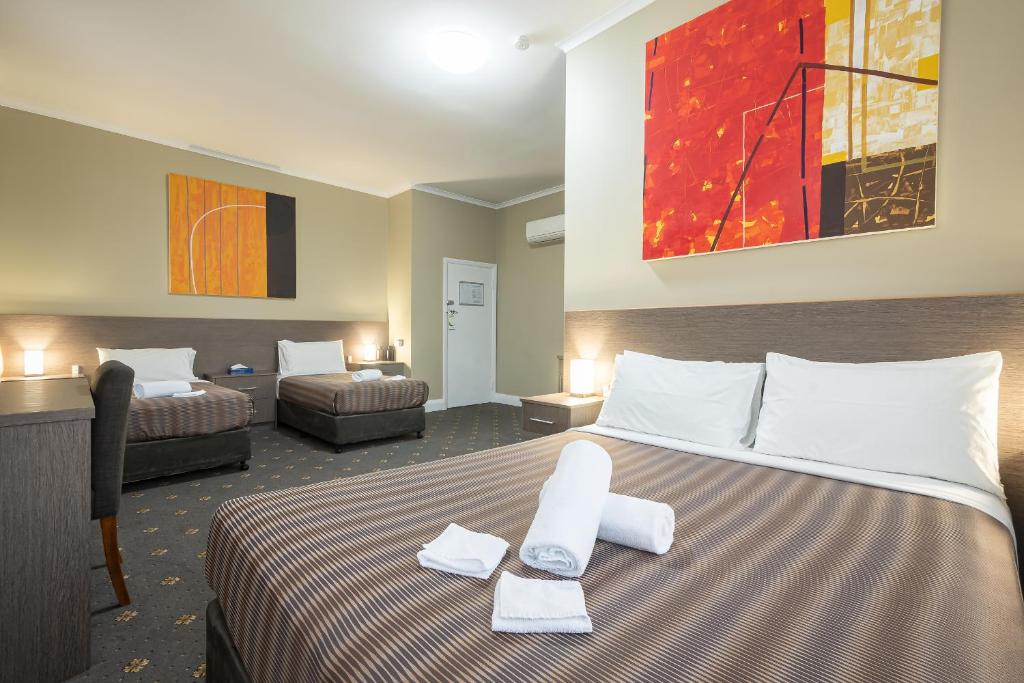 a hotel room with a large bed with towels on it at The Formby Hotel in Devonport