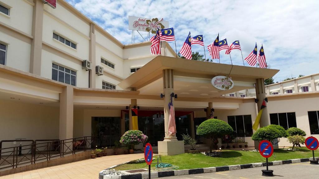 a building with american flags in front of it at Garden View Hotel in Bahau