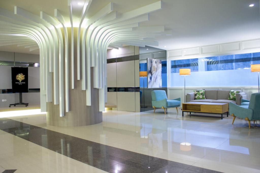 a lobby with a couch and chairs in a building at Nevada Ketapang Hotel in Ketapang