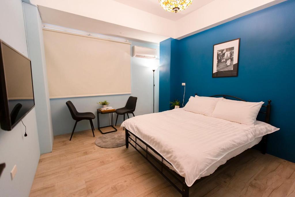 ein Schlafzimmer mit einer blauen Wand und einem Bett in der Unterkunft Lin Cuo Bian Homestay in Zhushan