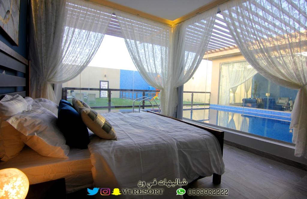 a bedroom with a bed and a large window at V1 Resort in Riyadh