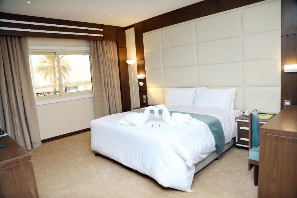 a hotel room with a large bed and a window at Ras Al Khaimah Hotel in Ras al Khaimah