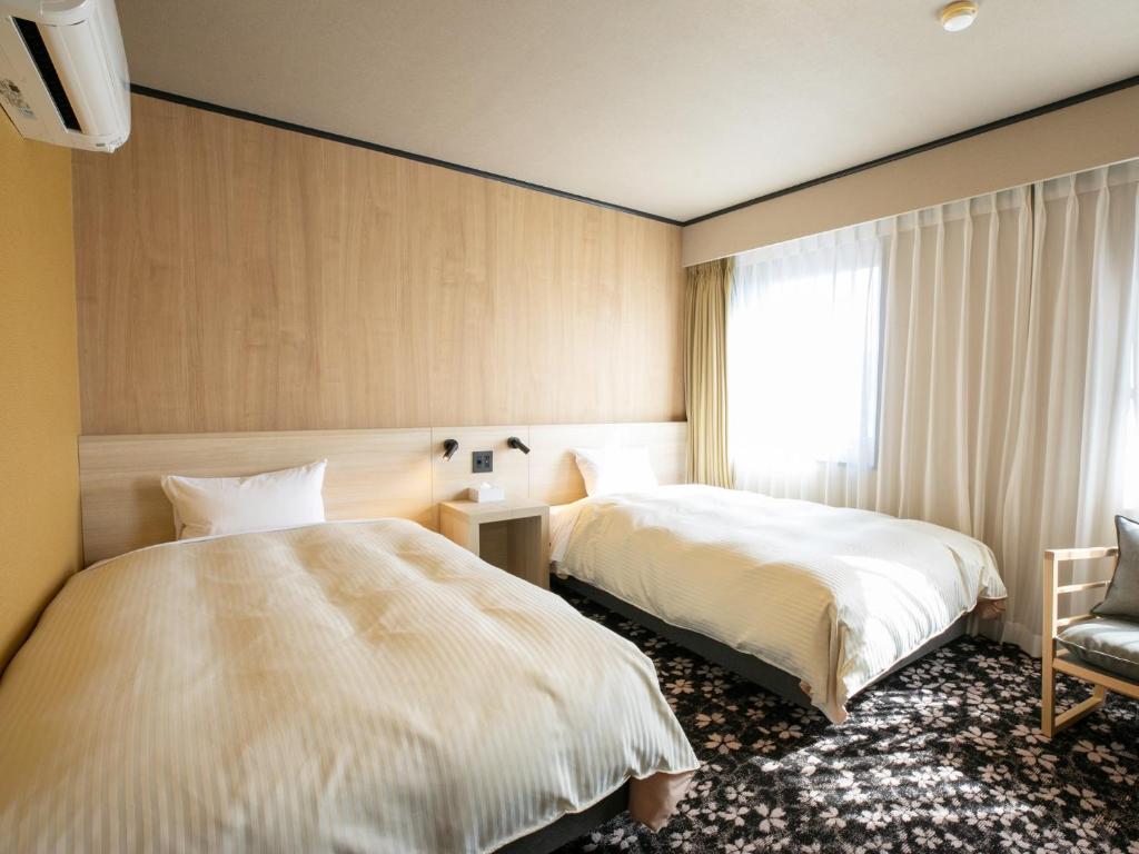 Postel nebo postele na pokoji v ubytování Maizuru Grand Hotel
