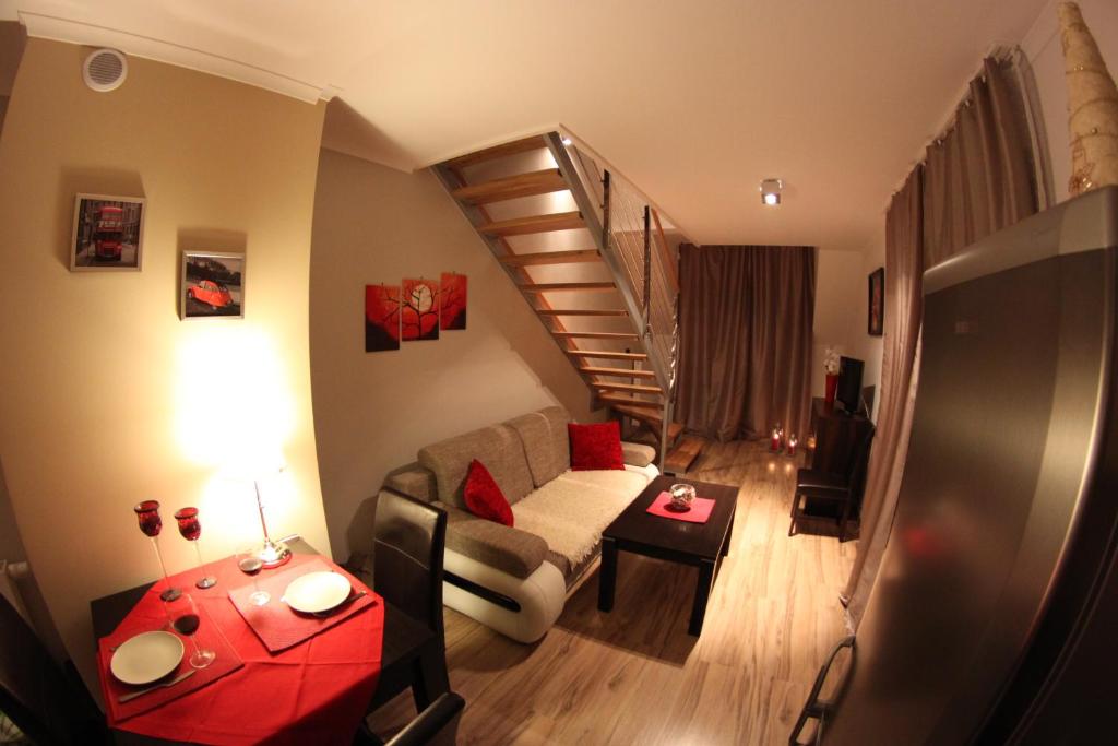 ein Wohnzimmer mit einem Sofa und einer Wendeltreppe in der Unterkunft Apartament Górski Widok - Mountain View in Wisła