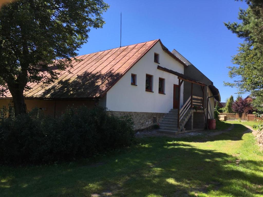 une maison blanche avec un toit rouge dans l'établissement Statek U Kalinů, à Nové Město na Moravě