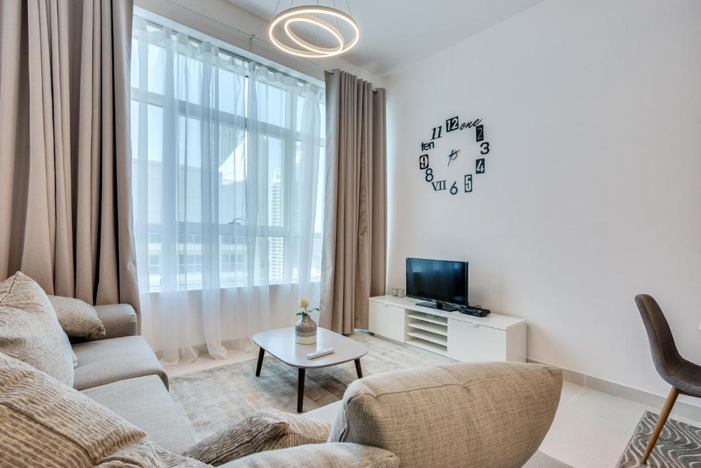 a living room with a couch and a tv at Stylish 2BD with great view in Marina View Tower in Dubai