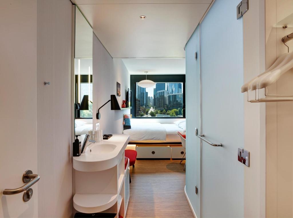 a bathroom with a sink and a bed in a room at citizenM Seattle South Lake Union in Seattle