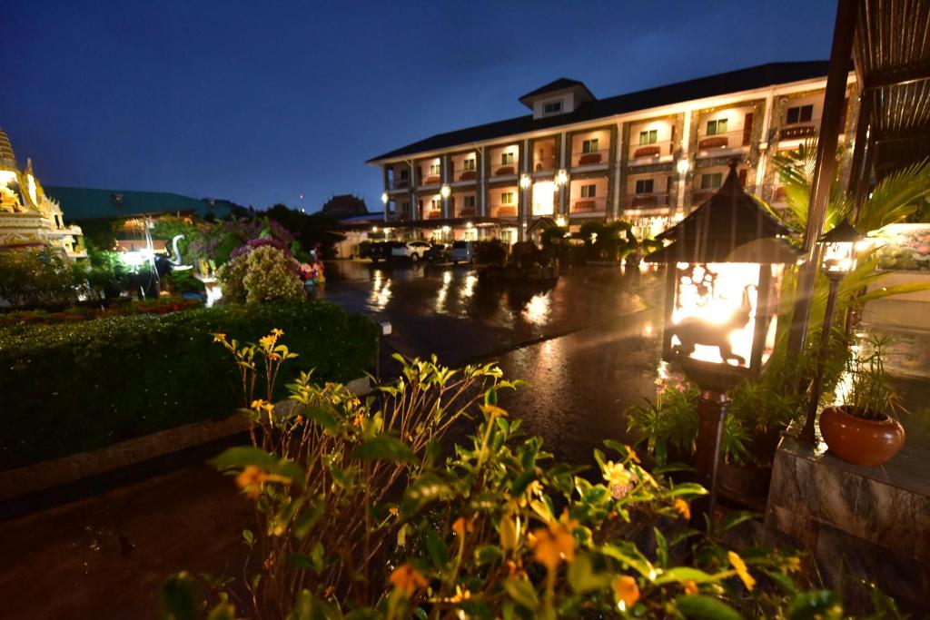 a hotel at night with lights in a courtyard at KT Knight Hotel in Surin