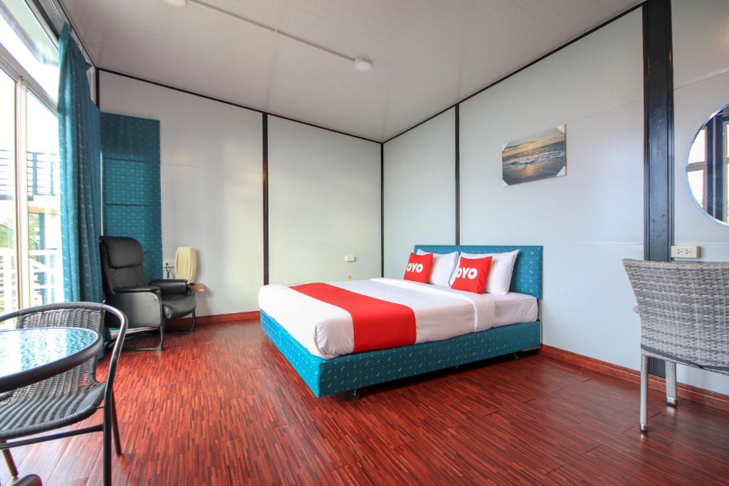 Habitación de hotel con cama, mesa y sillas en Happy Mountain Airport Resort en Nai Yang Beach