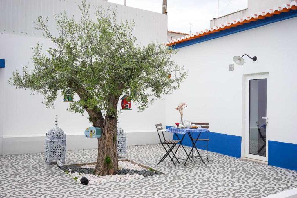 a tree in the middle of a floor with a table at Maria`s Guesthouse in Beja