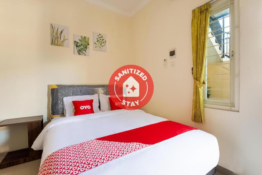 a bedroom with a bed with a red and white blanket at OYO 3398 Griya RM 19 Syariah in Surabaya
