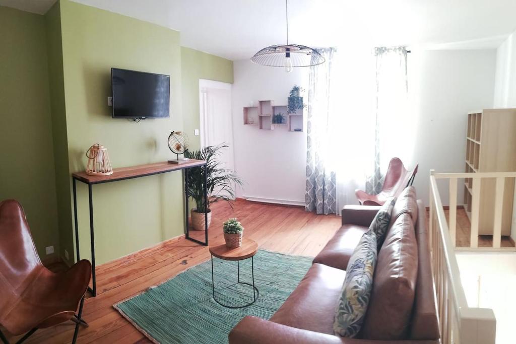 a living room with a couch and a table at Maison accueillante in Gondrecourt-le-Château