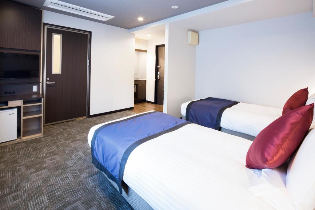 Postel nebo postele na pokoji v ubytování HOTEL MYSTAYS Kanda