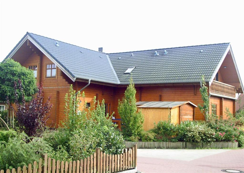uma grande casa de madeira com um telhado preto em Reuken - Fewo Zum Emslotsen em Emden