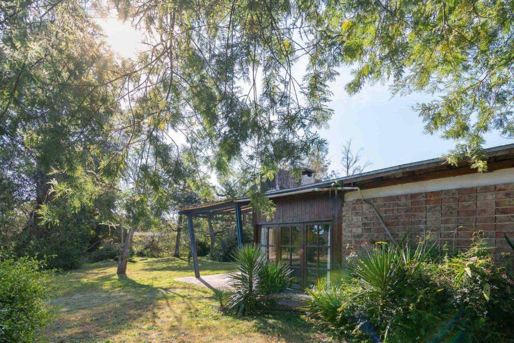 una casa de ladrillo con una gran ventana en un patio en Beach House in La Floresta, Uruguay en La Floresta