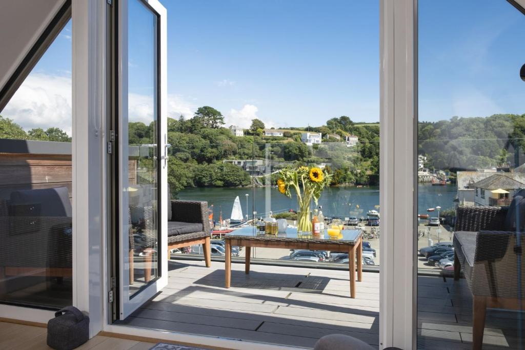 a balcony with a table and a view of the water at Fowey Penthouse, Fowey in Fowey