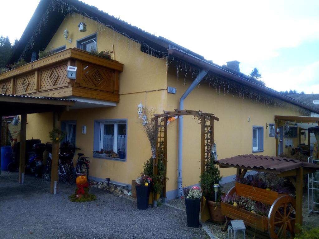 倫茨基希的住宿－Ferienwohnung Waldrast，黄色的房屋设有门廊和阳台