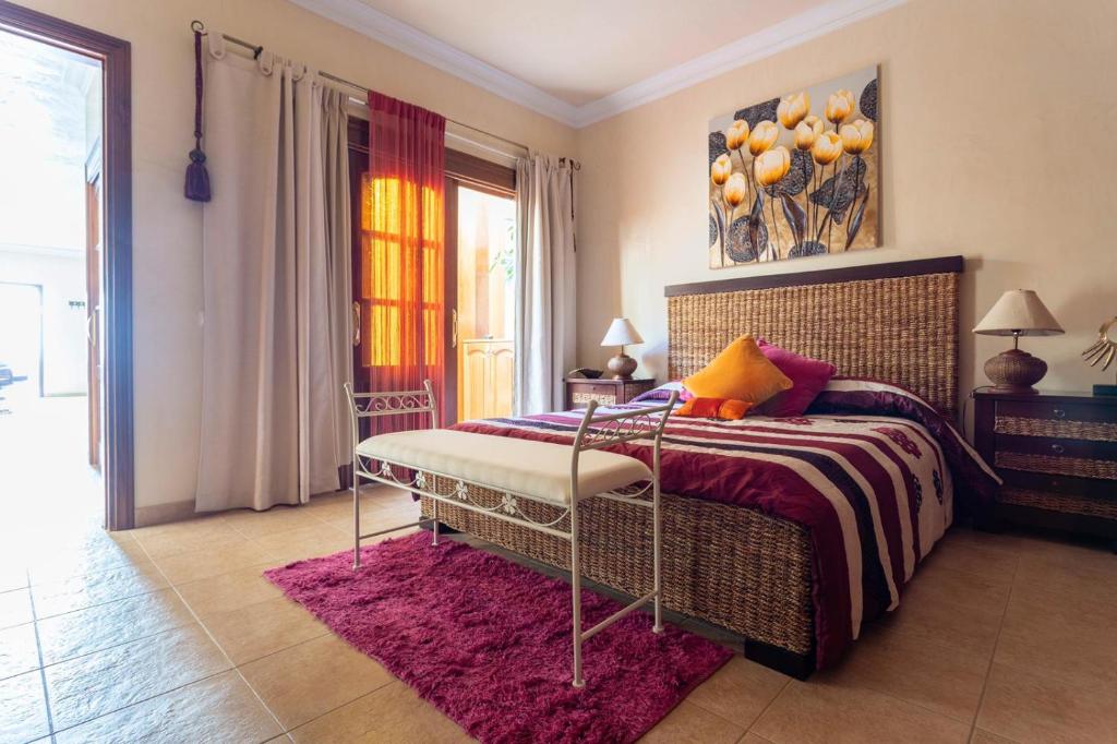 1 dormitorio con cama y alfombra rosa en Casa Lucia, en Playa Quemada