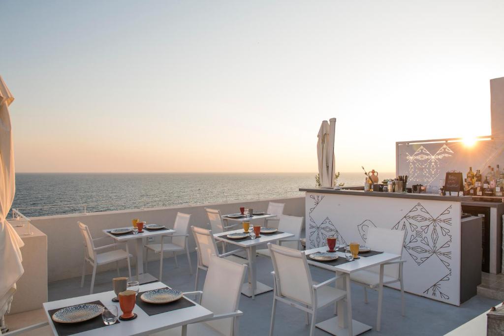 a restaurant with a view of the ocean with tables and chairs at Dimora Talenti in Polignano a Mare