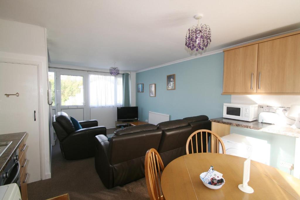 a living room with a couch and a table at Freshwater Bay Holiday Cottages in Pembroke