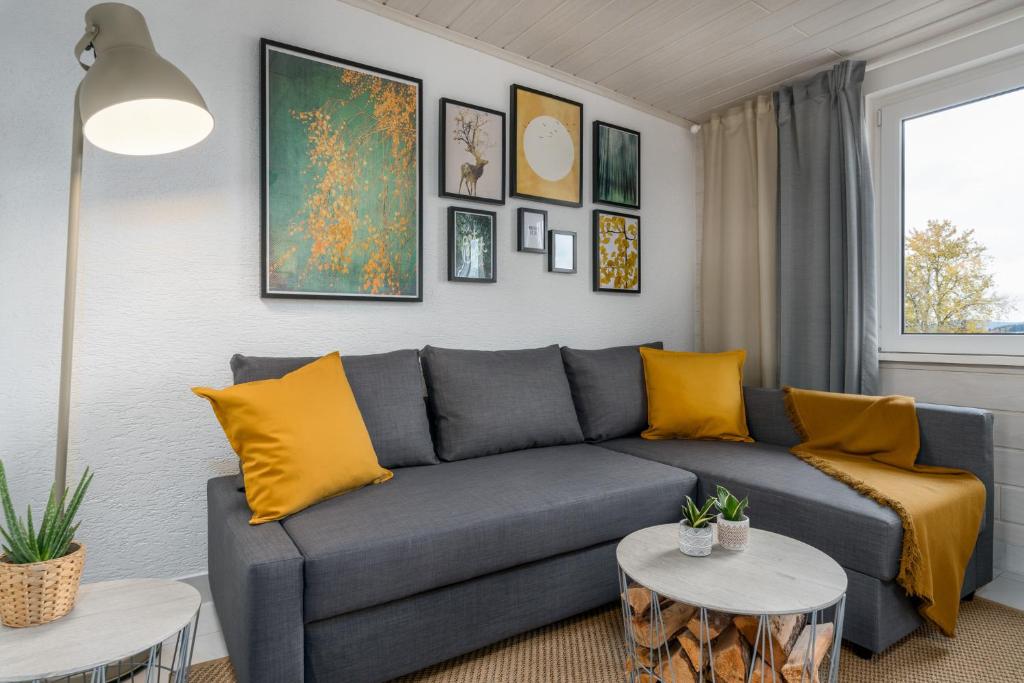 een woonkamer met een blauwe bank en gele kussens bij FOREST & MOUNTAIN - 2min Bikepark, Bikestore, SNES, Terrasse, SSC in Winterberg