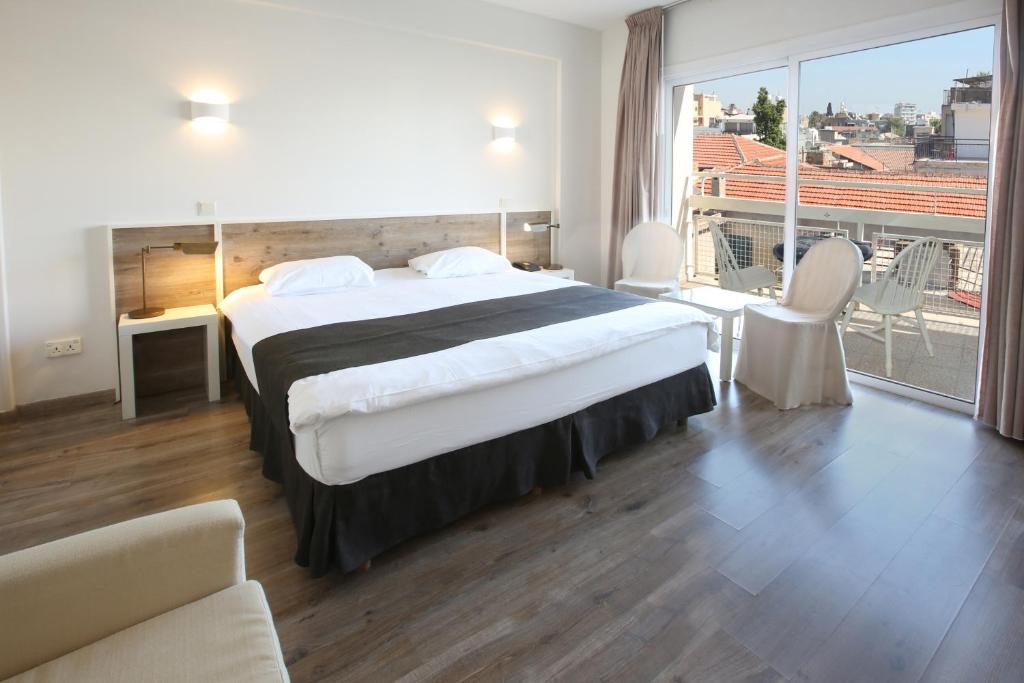 a hotel room with a large bed and a balcony at Centrum Hotel - City Center in Nicosia