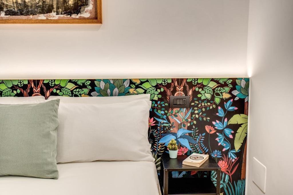 a bed with a headboard with a flowery wallpaper at Oasi Urbana 41 in Rome