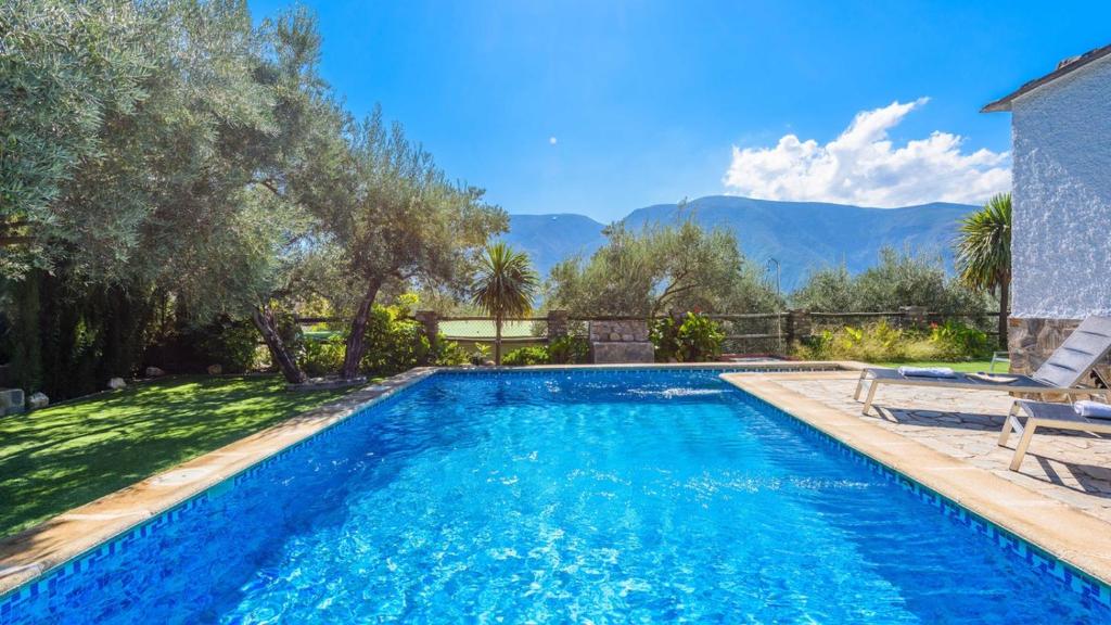 una piscina en un patio con montañas al fondo en Casa Las Gallinas Orgiva by Ruralidays, en Órgiva