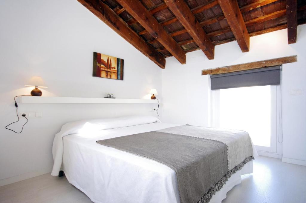 een witte slaapkamer met een wit bed en een raam bij Mosen Sorell Apartments in Valencia