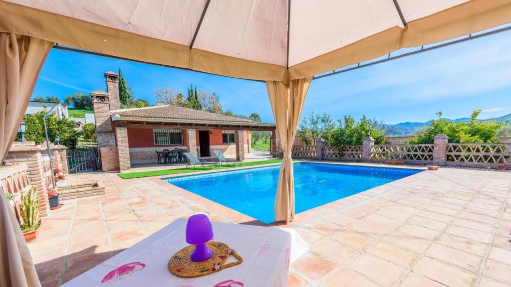 une villa avec une piscine et un parasol dans l'établissement Casa Rio Grande Tolox by Ruralidays, à Tolox