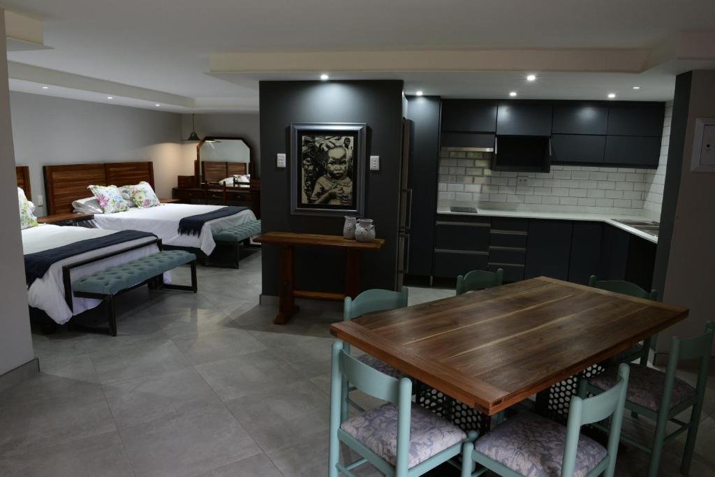 a room with a kitchen and a dining room with a table at 250onIndus in Pretoria