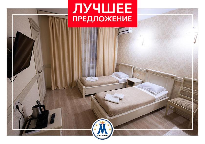 a hotel room with two beds and a tv at Oscar Hotel in Saratov