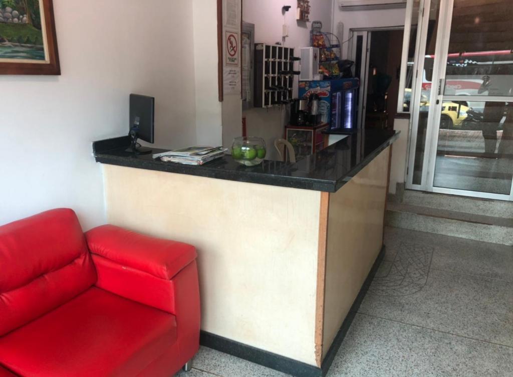 een rode bank voor een toonbank bij HOTEL PORTAL VICTORIA in Barrancabermeja