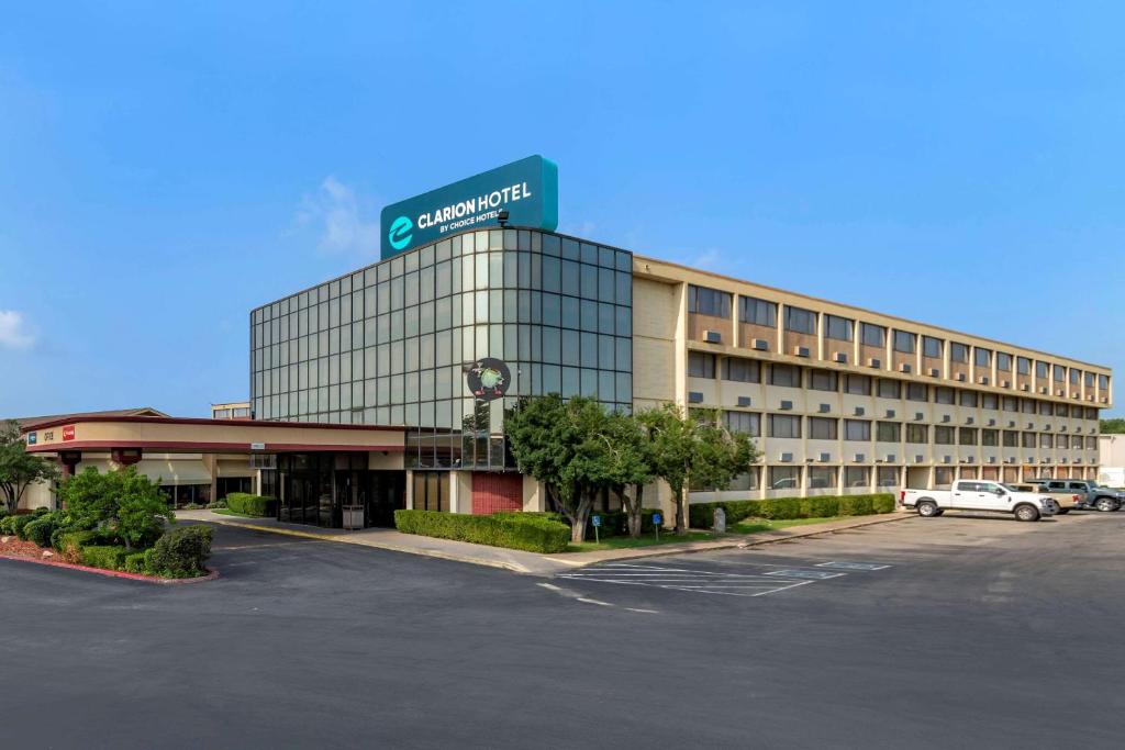 a building with a parking lot in front of it at Clarion Hotel Broken Arrow - Tulsa in Broken Arrow