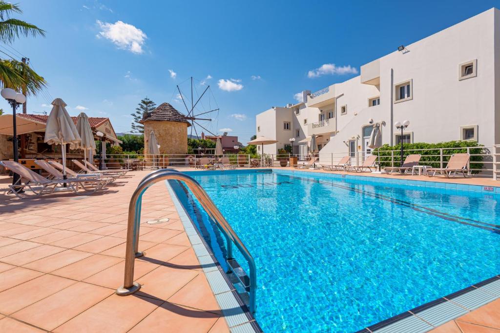 a swimming pool with a slide in front of a building at Mylos Apartments Anissaras in Hersonissos